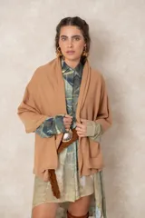 Pashmina de tejido suave con diseño asimétrico, cierre lateral con botón y acabado liso en color bordó.