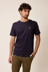 Remera básica de manga corta con cuello redondo y corte regular fit. Presenta un pequeño bordado en el pecho.