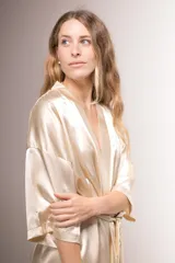 Bata kimono de satén blanco, con mangas al codo, largo por encima de la rodilla y lazo para ajustar en la cintura.