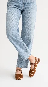 Chatitas Tabi estilo Mary Jane con diseño de punta dividida, confeccionadas en cuero con pelo estampado animal print tipo Bambi en tonos marrón y blanco. Poseen tira elástica sobre el empeine y tira ajustable en el talón.