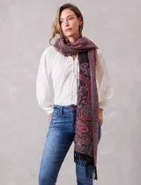 Bufandón rectangular de poliéster con estampado de arabescos en tonos rojos, azules y negros. Presenta terminaciones con flecos en los extremos.