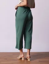 Pantalón capri plisado color beige, marca Dictionary, con pretina ancha elastizada y bolsillos delanteros.