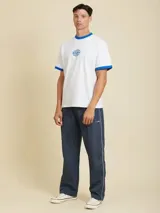 Remera blanca de manga corta estilo ringer, con cuello redondo y ribetes en color azul. Presenta un pequeño estampado circular en el pecho.