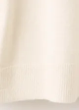 Chaleco de punto color blanco con detalles de líneas negras en los hombros y sisas, cuello alto y diseño holgado.