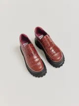 Mocasines de plataforma alta con diseño de estilo rebelde. Presentan un estampado de cuadros en tonos violeta y amarillo, confeccionados en lona con detalles en cuero. Cuentan con una suela robusta y elásticos laterales ocultos para facilitar el calce.