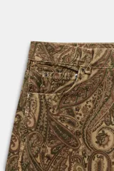 Jeans de tiro medio con diseño de perneras curvas y corte recto, confeccionados en denim con estampado paisley en tonos marrones y beige. Presentan diseño clásico de cinco bolsillos, trabillas para cinturón y cierre frontal con cremallera y botón metálico.