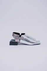 Sandalias de cuero color marrón con puntera abierta, talón descubierto y tira trasera con hebilla. Taco bajo de madera.