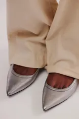 Zapato plano negro de cuero, tipo chatita, con punta fina y tiras con hebilla ajustable alrededor del tobillo.