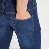 Jean slim de hombre color azul, con cierre de botón y cremallera, y bolsillos delanteros y traseros.