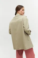 Tapado corto de silueta relajada con doble botonadura, solapas amplias y bolsillos laterales funcionales.
