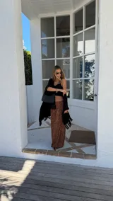 Ruana negra de tejido liviano con terminación de flecos en el ruedo y mangas amplias.