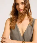 Vestido corto sin mangas confeccionado en crepé con estampado de cuadros. Presenta escote en V tanto en la parte delantera como en la trasera, breteles anchos y lapelas delanteras con botones estilizados.