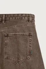 Pantalón barrel fit de mezclilla color verde militar, con efecto lavado, cinco bolsillos, cierre frontal con cremallera y botón, y detalle de pinzas en las rodillas.