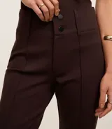 Pantalón acampanado de viscosa color marrón chocolate, con cintura alta, cierre frontal con botones y bolsillos traseros.