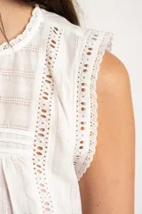 Blusa sin mangas de algodón color blanco, con cuello redondo, detalles de encaje y diseño fruncido en el frente.