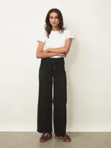 Jean de corte wide leg en color negro, con cintura alta ajustable mediante lazo y costuras verticales decorativas en el frente.