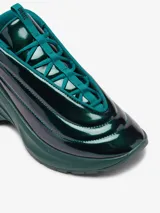 Zapatillas Diesel D-Runner color verde oscuro brillante, con diseño sin cordones y cordones elásticos cruzados.