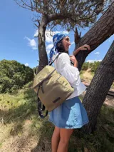 Mochila urbana de diseño compacto en color negro, confeccionada en nylon resistente. Cuenta con un compartimento principal con cierre, bolsillo frontal con cierre y correas ajustables con detalle de marca.