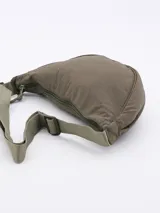 Morral tipo riñonera o bandolera de color negro, con cuerpo acolchado y correa ajustable de tela verde militar.