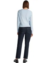 Sweater de mujer color celeste claro, tejido en punto trenzado (cable knit) con cuello redondo y manga larga. Presenta un pequeño logo bordado de la marca en el pecho.