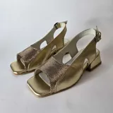Sandalias de cuero combinadas en negro y beige, con puntera cuadrada, taco bajo y tira ajustable en el talón.