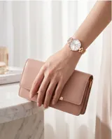 Reloj analógico de mujer con caja redonda y malla de eslabones en tono oro rosa. Presenta una esfera minimalista con índices lineales y movimiento de cuarzo japonés.
