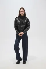 Campera de eco-cuero negro con cuello alto, cierre frontal, bolsillos con solapa en el pecho y puños y ruedo elásticos.