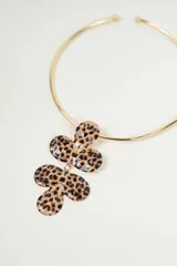 Set de collar y aros dorados con dije de flor con estampado animal print. El collar es tipo choker y los aros son colgantes.