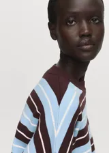 Sweater de punto fino con diseño oversize y estampado de rayas horizontales en tonos marrón, celeste y blanco. Presenta cuello redondo y mangas largas.