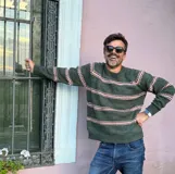 Sweater de punto con cuello redondo, diseño de rayas horizontales en tonos oscuros sobre base clara, de manga larga y calce cómodo.