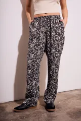 Pantalón recto de viscosa con estampado de hojas en blanco y negro, tiro medio y cintura elastizada.