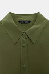 Camisa de manga larga color celeste claro, con cuello solapa y cierre frontal de botones.