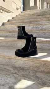 Botas cortas de cuero combinado en tonos tostado, marrón y detalles en charol negro. Cuentan con suela chunky, taco de 6 cm, cierre lateral y laterales de gamuza.