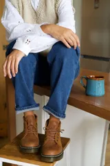 Borcego de cuero color marrón con cordones y suela de goma.