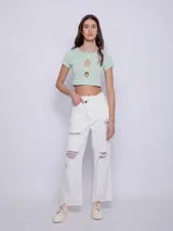 Top corto de manga corta color amarillo con estampado de lunares blancos y aberturas circulares en el escote.