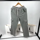 Pantalón de jogging gris con cintura elástica ajustable con cordón, bolsillos laterales y bolsillos cargo con solapa en los muslos.