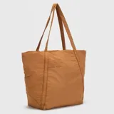 Bolso tipo tote de diseño amplio y ligero, confeccionado en tela técnica de acabado mate. Presenta doble asa superior para llevar al hombro, bolsillo frontal abierto y logo de la marca sutilmente grabado en la parte superior.