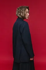 Blazer azul marino con cuello alto y cierre frontal cruzado.