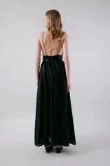 Vestido largo negro con escote en V profundo y breteles finos. Tiene una banda ancha debajo del busto y falda amplia con forro. La espalda es baja y tiene cierre invisible.