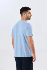 Remera azul marino de manga corta con cuello redondo, confeccionada en mezcla de algodón y poliéster. Presenta un diseño en el frente que combina estampa y bordado con la leyenda "Legacy Brand 1972" en tonos rosado, verde y marrón.