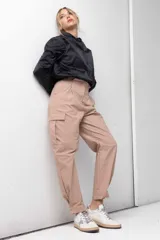 Pantalón gris de tiro alto con pinzas, bolsillos cargo laterales y ruedo ajustable con botones.