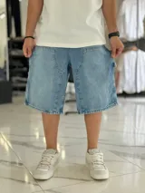 Bermuda de jean estilo carpintero, color celeste, con bolsillos laterales amplios, presilla para herramientas y diseño amplio de corte oversize.