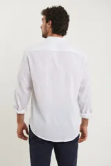 Camisa de cuello mao y manga larga, confeccionada en una mezcla de lino y algodón. Presenta un diseño de corte recto con botones en tono natural y un bolsillo pequeño en el pecho.