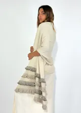 Chal de punto color beige con textura calada y volados en los bordes.