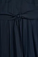 Vestido midi de estilo camisero color bordó, con cuello solapa, escote en pico y cierre frontal con botones ocultos. Presenta manga larga, bolsillos laterales ocultos, solapas decorativas en el pecho y cinturón de lazada en el mismo tejido.