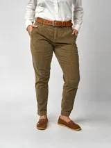 Pantalón de pana negro de corte recto, con bolsillos laterales y traseros. Se ajusta a la cintura con cinturón de cuero negro.