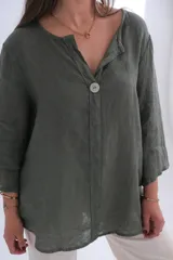 Blusa verde oliva de lino con cuello en V, manga tres cuartos y cierre frontal con un botón.