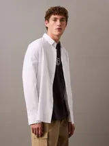 Remera gris oscuro de algodón regenerativo, con cuello redondo, manga corta y logo CK Shield bordado en el pecho.
