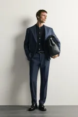 Blazer regular fit azul marino confeccionada en tejido con 20% de lana. Cuenta con cuello con solapas de muesca, manga larga con botones en los puños, bolsillos de vivo en el pecho y de solapa en la cadera, y cierre frontal con botones.