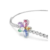 Pulsera bañada en rodio con cadena de cristales transparentes y motivo central de flor silvestre, compuesta por pétalos de cristales de colores en tallas mixtas y una perla de cristal en el centro. Cuenta con un cierre deslizante ajustable.